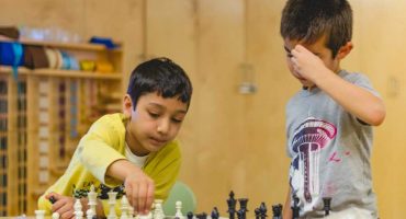 Elementary Montessori School Students Playing Chess During Summer Camp