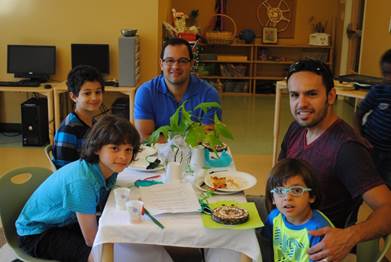 A loving father and his little boy are joining another father and his two little boys for a pancake breakfast.
