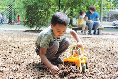 A Camper Loading Wood Chips With A Toy Front End Loader On The Playground